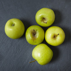 Aerial view of green apples on a rustic slate background