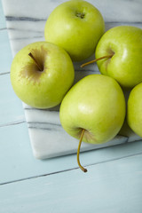 Green apples on a painted wood and marble background, arranged to form a page border