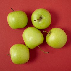 Aerial view of green apples on a bright red background