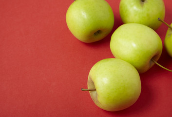 Green apples on a bright red background forming a page border