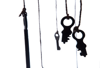 Many rustic keys hanging on string. Selective focus. Isolated