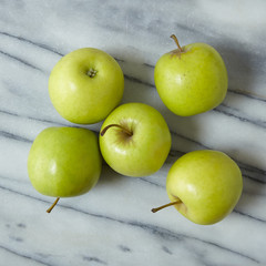Aerial view of green apples on a marble counter background