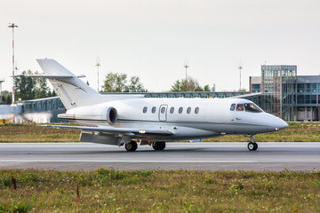 Fototapeta na wymiar Business Jet on the runway in front of the airport terminal