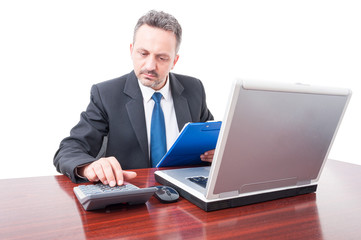 Man at office holding clipboard and calculating