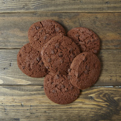 Aerial view of a pile of chocolate chip cookies on a rustic wooden counter top background