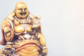 laughing golden Buddha on the toad. Copy space