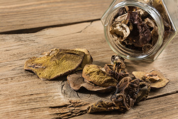 Dried mushrooms in a jar on a wooden table