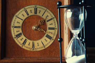 Hourglass and old vintage clock