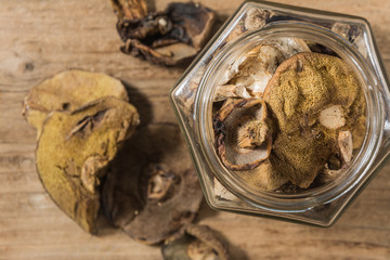 Dried mushrooms in a jar on a wooden table