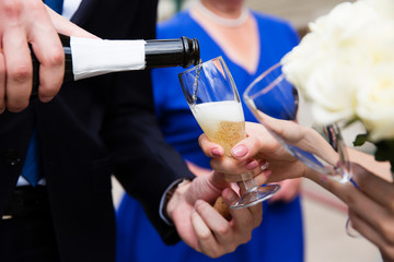 Pouring champagne into a glass on a wedding celebration