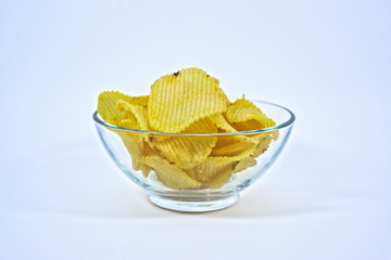 Crinkle cut potato chips in a bowl on a white background