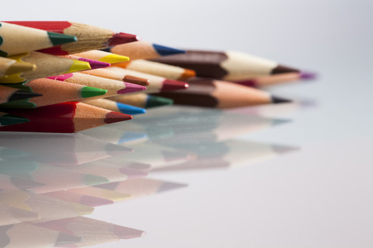 Group of sharp colored pencils with white background and reflexions