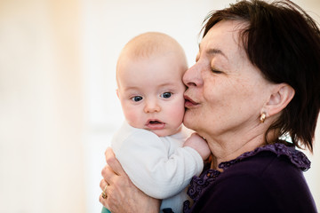 Senior woman kisses her grandchild