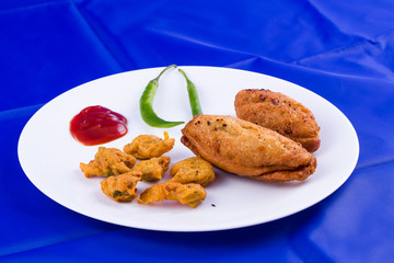 Indian food - bread roll with fish stuffing and veg pakora