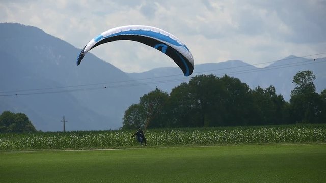 Blue paraglider is landing