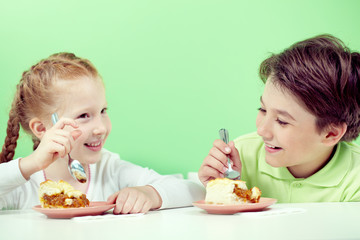 Two little children eating pie