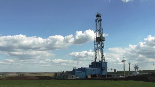 Drilling Rig On Drilling Site. Drilling rig for gas production. View from a distance on a background of blue sky