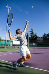 Fototapeta na wymiar Professional tennis player man playing on court