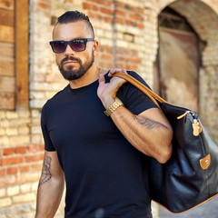 Fashion portrait of handsome man in sunglasses and black modern