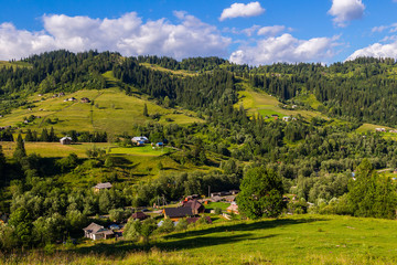 Rural houses in village Dzembronia at Carpathian mountains, nature summer landscape, Ukraine.