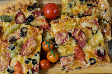 pizza with sausage, olives, tomatoes and cheese