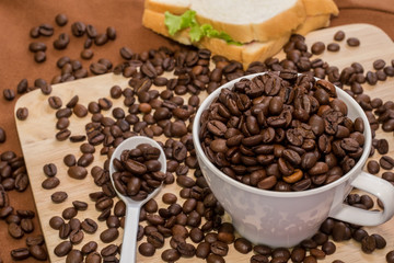 Coffee Cup with coffee beans on wood of coffee beans and sanback
