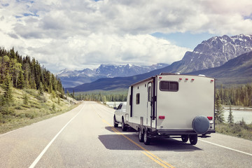 Caravan or motor home trailer on a mountain road - obrazy, fototapety, plakaty