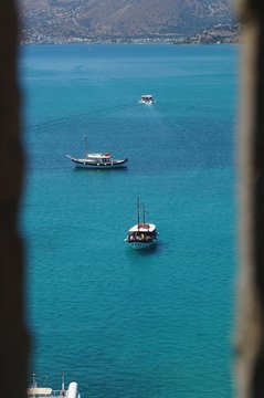 Boats in Aegean sea seen through the embrasure of the Spinalonga fortress