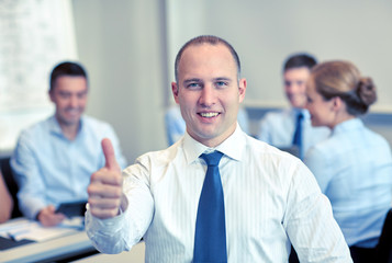 group of smiling businesspeople meeting in office