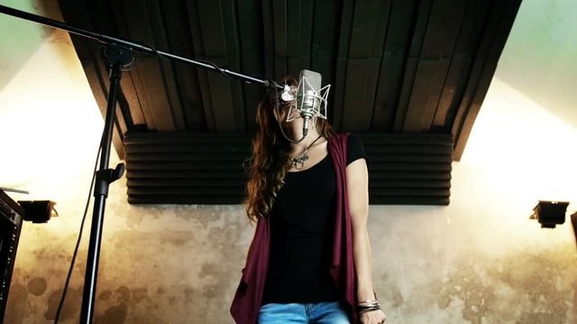 Beautiful woman recording in studio