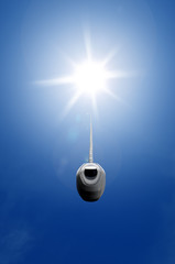 Lamp switch connected to the sun in blue sky, illustrating renewable energy