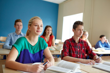 group of students with books at school lesson