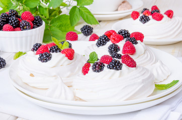 Meringue cakes Pavlova with whipped cream and fresh berries