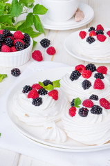 Meringue cakes Pavlova with whipped cream and fresh berries