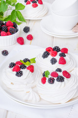 Meringue cakes Pavlova with whipped cream and fresh berries