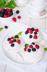 Meringue cakes Pavlova with whipped cream and fresh berries
