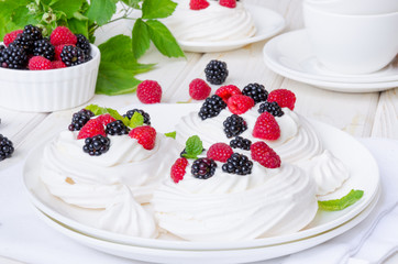 Meringue cakes Pavlova with whipped cream and fresh berries