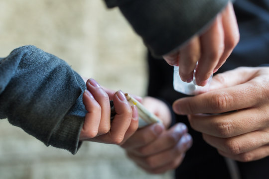 Close Up Of Addict Buying Dose From Drug Dealer