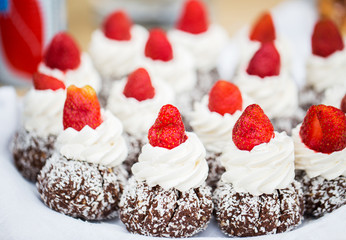 close up of rum cakes with custard and strawberry