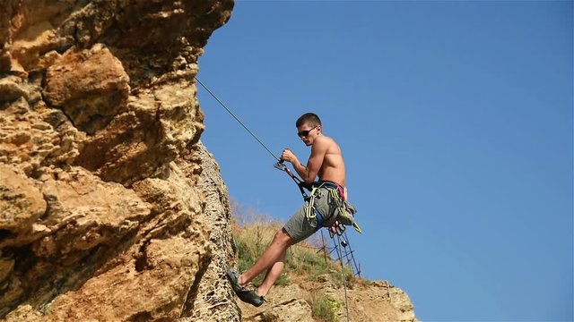 Rock Climber Descends A Rope From A Cliff. Slow Motion Effect