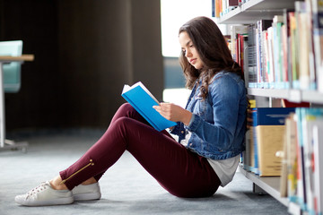 high school student girl reading book at library - Powered by Adobe