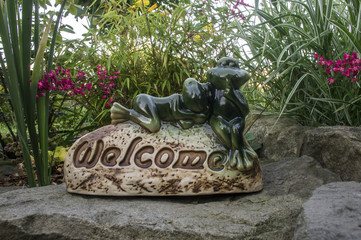 Fototapeta porcelanowa figurka welcome witajcie z żabkami w zacisznym zakątku obraz