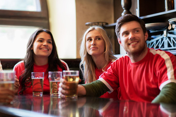 fans or friends watching football at sport bar