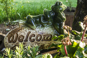 Fototapeta porcelanowa figurka welcome witajcie z żabkami w zacisznym zakątku obraz