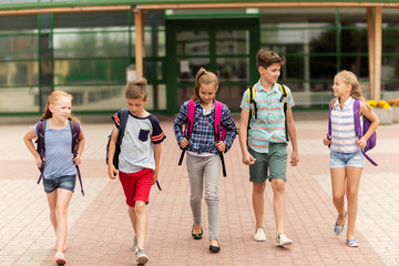 group of happy elementary school students walking