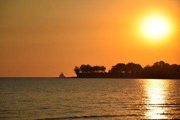 Sonnenuntergang am Meer mit Palmen und Schiff am Horizont