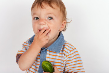 Fototapeta premium Hungry baby boy eating cucumber
