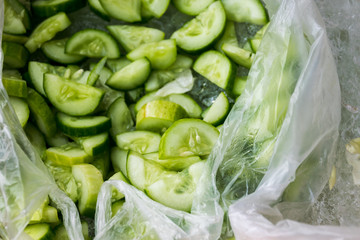 Cucumber slices in white plastic bag soaked on the ice.