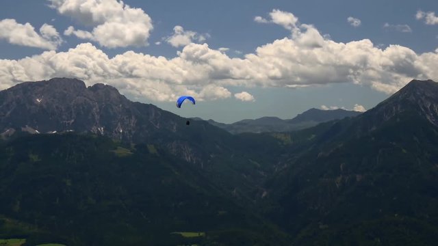 Paraglider over mountain peaks
