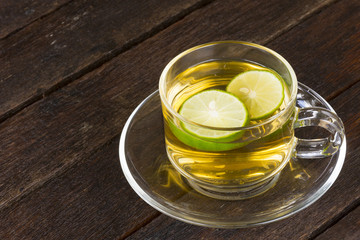 Hot lemon tea in glass on old wooden background.Close up